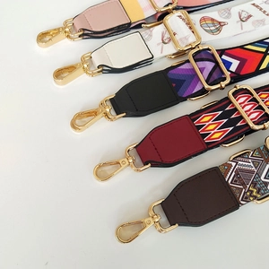 Detail of colorful ethnic style wide guitar straps for bags with gold metal lobster hooks