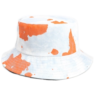 Tie-dye reversible bucket hat featuring orange cow print on a light blue cotton base
