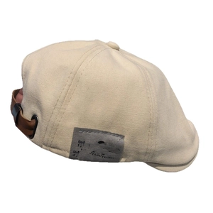 Cream cotton flat cap with gray side patch and adjustable brown leather back strap