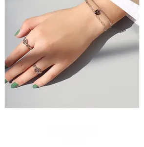 Détail d'un bracelet double argenté avec pendentif Lucky et ensemble de bagues
