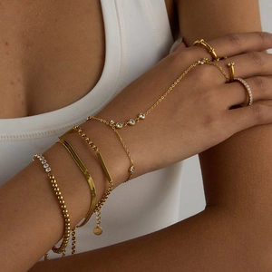Close-up of gold stainless steel finger bracelet with layered beaded and snake chains
