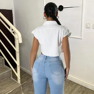 Vue arrière d'une chemise courte blanche tendance et d'un jean bleu à taille haute