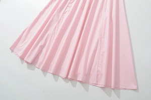 Detail of pink pleated dress hemline showing elegant fabric drape and fine texture