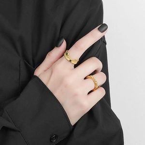 Set di anelli dorati con trama a lava e pietre verdi in stile minimalista chic