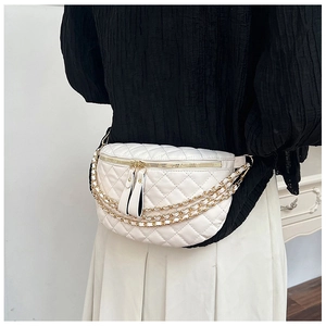 Detail of white quilted waist bag featuring double gold zippers and tiered metal chains