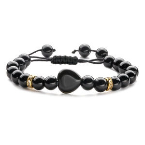 Dettaglio del bracciale a sfere nere regolabile con ciondolo a cuore e distanziatori dorati