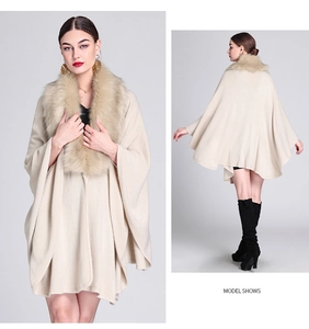 Front and back view of a beige knit poncho with faux fox fur collar on a model