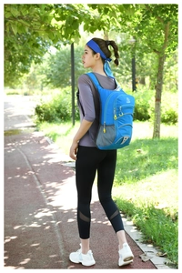 Blue outdoor sports backpack with breathable mesh side pockets shown during a hiking session