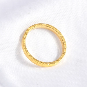 Macro detail of irregular hammered texture on a 18K gold plated stainless steel ring