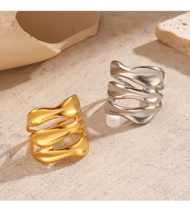 Macro shot of irregular wavy layered rings in gold and silver finish on stone background