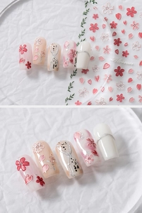 Macro shot of 5D embossed cherry blossom nail stickers with pink petals and silver accents