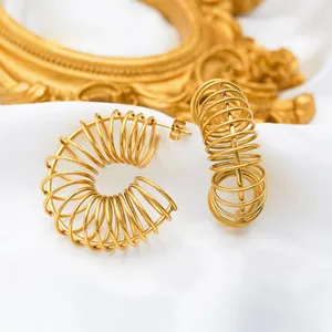 Detail of 18k gold plated stainless steel spring hoop earrings on white silk