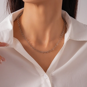 Close-up of geometric circular link necklace in silver finish on a model's neck