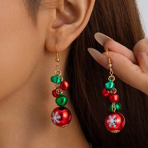 Gros plan de boucles d'oreilles clochettes avec flocons de neige portées par un modèle