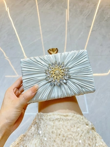 Details der blauen Seiden-Abendtasche mit Faltenstruktur und Kristallblumen-Dekoration