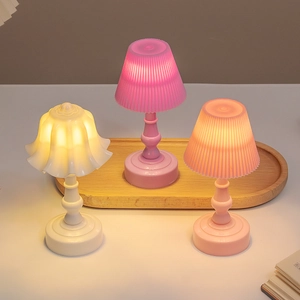 Mini lily of the valley night lights in white, pink, and coral colors on wooden tray