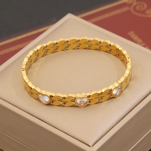 Détail macro d'un bracelet coeur doré avec zircons clairs sertis sur présentoir à bijoux