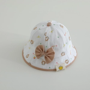 Détail du chapeau de soleil pour bébé avec motifs donuts et nœud papillon marron