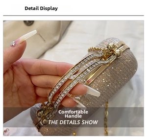 Detail of glitter clutch bag featuring rhinestone double handles and golden snap closure