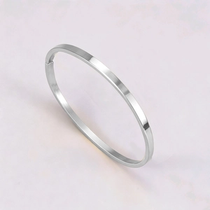 Macro detail of silver titanium steel bangle with polished flat surface and hinge clasp