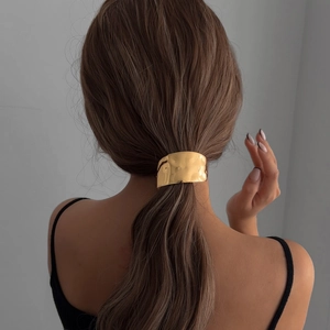 Golden hammered metal ponytail cuff hair tie shown on a model with brown hair