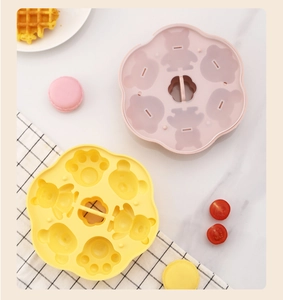 Close-up of cat paw and bear shaped silicone baby food mold on marble table
