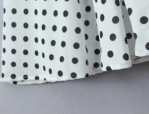 Détail du motif à pois noirs élégant sur le tissu en mousseline de soie blanche de qualité