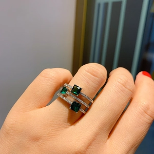 Macro detail of triple-layer silver ring featuring three emerald-cut green gemstones