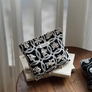 Detailed embroidery texture on a cotton canvas pouch with simple wish label on book