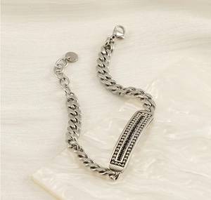 Dettaglio del bracciale a catena cubana in acciaio inossidabile con piastra e moschettone