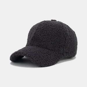 Detailed close-up of thick black lambswool baseball cap showing warm textured fleece fabric