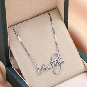 Custom silver name necklace with Audrey script pendant on a premium jewelry box