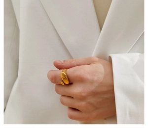 Close-up of minimalist gold geometric oval open ring worn on a model finger