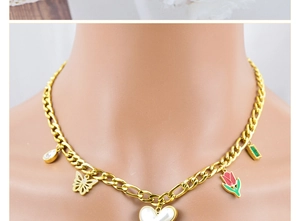 Close-up of golden necklace with colorful butterfly, tulip, and heart charms on neck