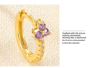 Dettaglio macro di orecchini a cerchio in argento S925 dorato con fiori in zirconia viola