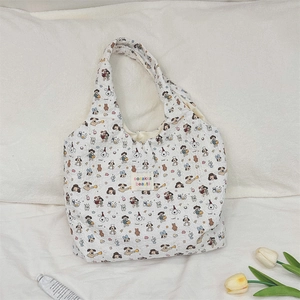 Détail du sac cabas en toile matelassée avec motifs de chiens et étiquette tissée