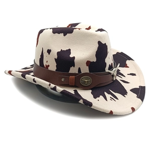 Detail of western cow print felt hat featuring a metal bull head badge on leather band