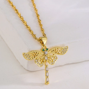 Macro detail of gold-plated dragonfly pendant necklace with green and clear zircon stones