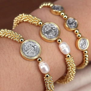 Detail of adjustable gold beaded bracelets with Saint Benedict medal and baroque pearls