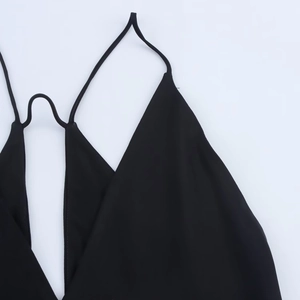 Détail de la texture en satin noir lisse et de la fine bretelle de la robe d'été