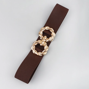 Detail view of a dark brown elastic waist belt with a twisted gold metal buckle for dresses