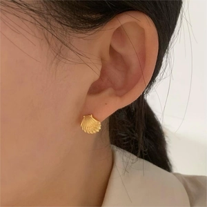 Elegant 925 sterling silver shell stud earrings with gold finish on a female model