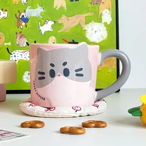 Detail of pink lucky kitten ceramic mug with gray cat illustration and meow text