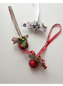 Detailed view of Christmas iron bells with pine needles, berries, and festive ribbons