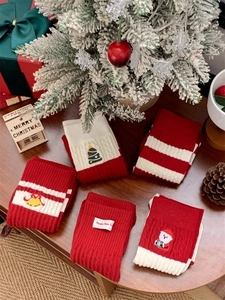 Détail de chaussettes de Noël en tricot rouge et blanc avec broderie sur table de fête