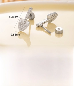 Macro shot of silver shovel-shaped cartilage piercing with cubic zirconia and screw back