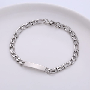 Close-up detail of a silver stainless steel Figaro chain bracelet featuring a blank ID bar