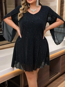 Dettaglio vestito nero con paillettes, scollo a V e maniche a fessura trasparenti