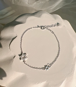 Macro detail of silver star bracelet with pavé-set zircons and polished hollow star charm
