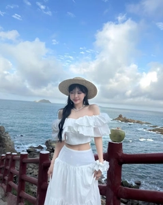 Outdoor seaside shot of white off-the-shoulder top and matching long skirt set
